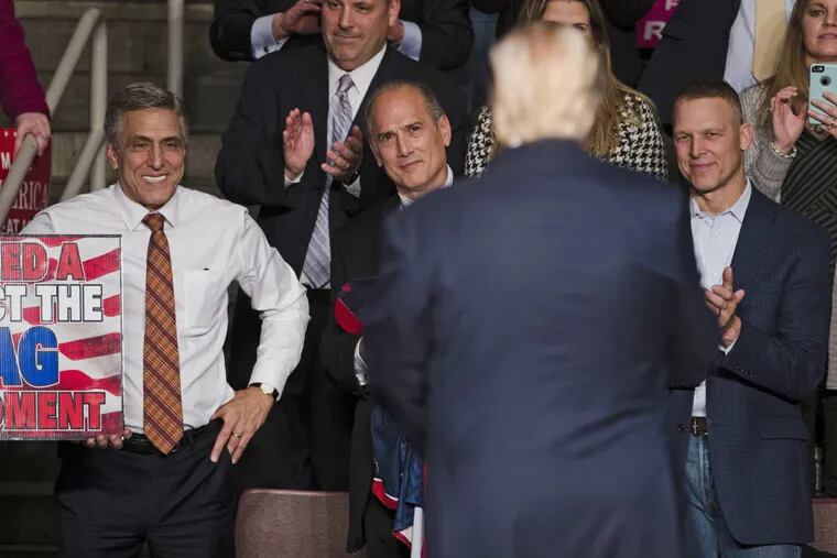 U.S. Rep. Lou Barletta (left) watches as  President-elect Donald Trump leaves  a rally in Hershey, Pa. last December.