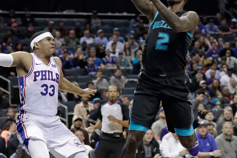 Charlotte Hornets' Marvin Williams (2) shoots against Philadelphia 76ers' Tobias Harris (33) during the first half of an NBA basketball game in Charlotte, N.C., Tuesday, March 19, 2019. (AP Photo/Chuck Burton)
