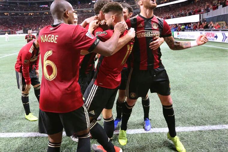 Atlanta United players mob Hector Villalba after his goal in their 3-0 victory over the New York Red Bulls.