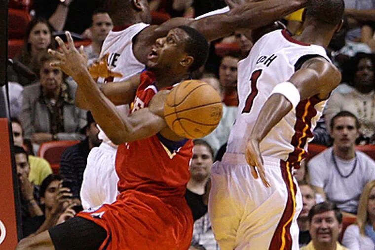 Thaddeus Young is fouled by Miami Heat's Dwyane Wade, left, and Chris Bosh. The Heat beat the 76ers, 99-90. (AP Photo/Lynne Sladky)