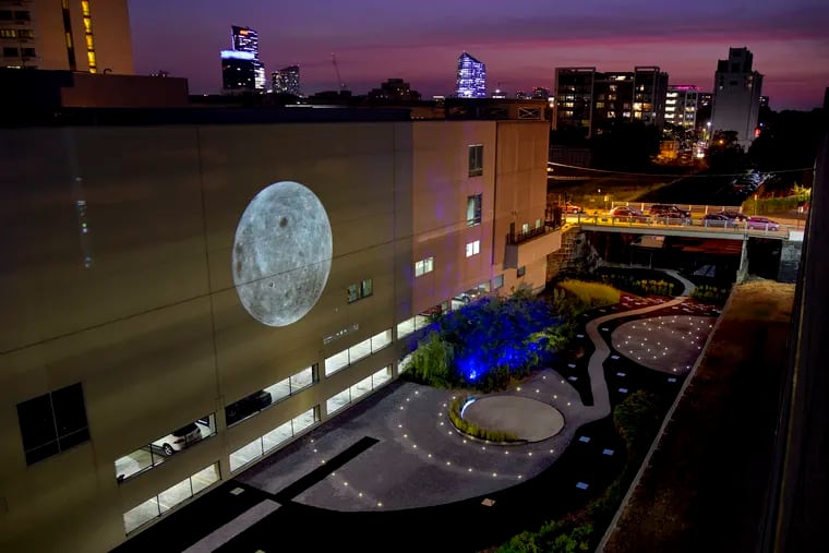 Artists run through their building-sized nighttime video projections titled “Moon Viewing Platform (First Quarter Moon),” in The Cut, between 17 and 18th Streets, north of Callowhill Street October 1, 2019, one of the installation performances in advance of the weekend opening of “Site/Sound: Revealing the Rail Park.” Three core installations will take place in various locations along the path of the current and future Rail Park on three Saturdays in October.