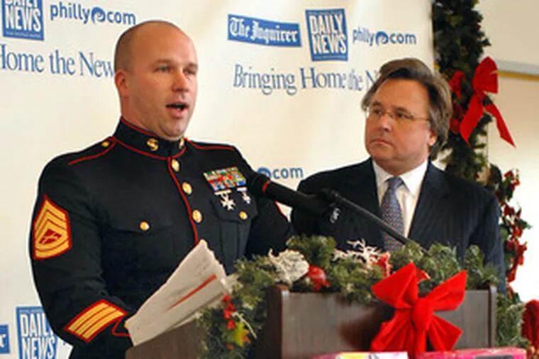 Publisher Brian P. Tierney (right) and Gunnery Sgt. Robert Putney are surrounded by toys in the lobby of The Inquirer and Daily News Building. The media firm is helping gather more toys.