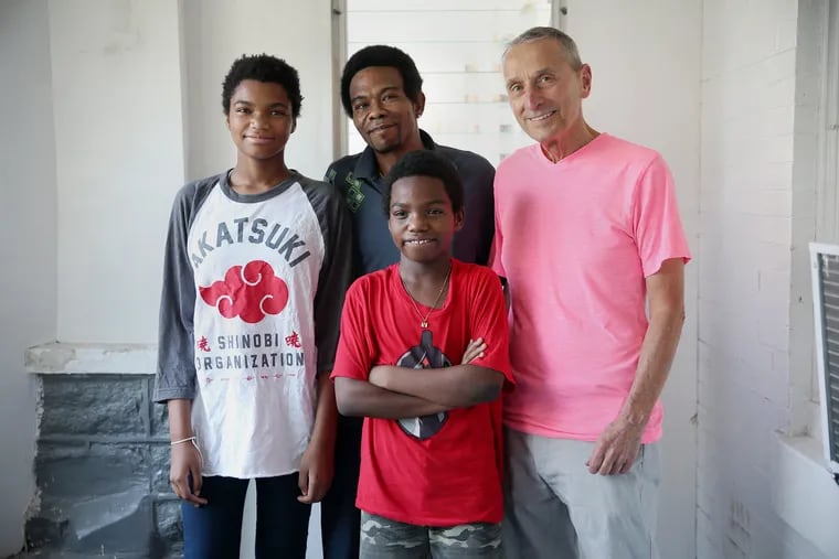 Ed Riehl, president of the Delaware Valley Fairness Project, pictured with Cheyenne Brown, 12, left; her father, Charles, center rear; and her brother, Zion, 11, at their Southwest Philadelphia home. Riehl's organization works with under-resourced schools and families.