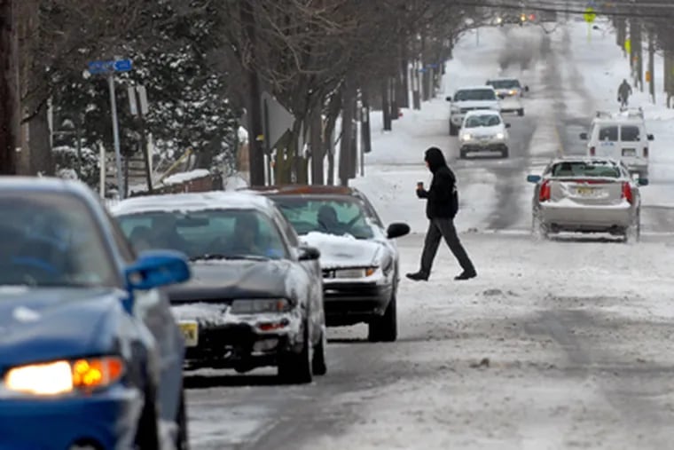 Cars and pedestrians share the road along Collins Avenue near the PATCO station in Collingswood, as the streets are mostly cleared in time for the Monday morning commute. (Tom Gralish / Staff Photographer)