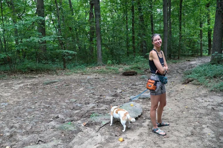 Animal activist Aminda Edgar walks her dog, Todd, in Carpenter's Woods in Mount Airy, where people have been abandoning their pets.
