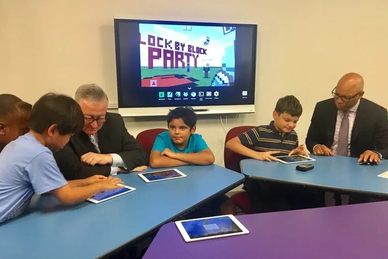Mayor Kenney (left) and Superintendent William R. Hite Jr. learn how to play Minecraft from a group of Philadelphia children.
