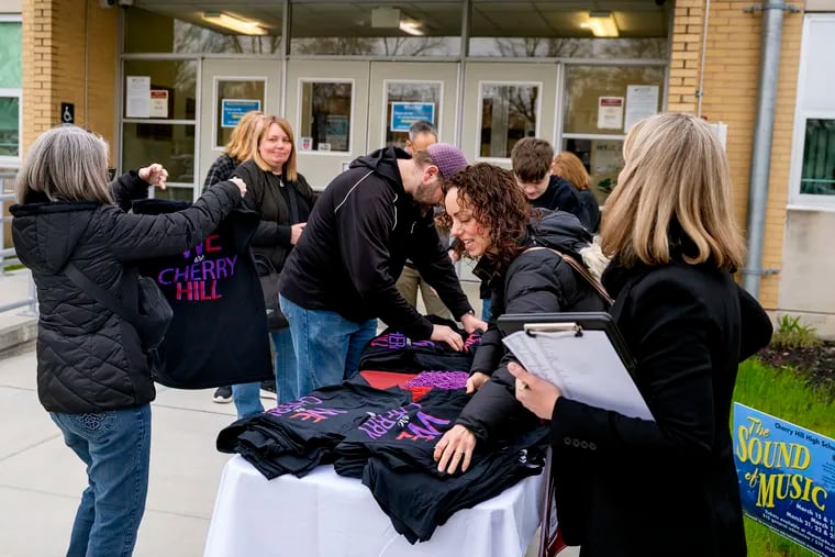 The Cherry Hill teachers union, parent teacher organization members and Board of Education staffers grab T-shirts as they gathered at district headquarters last month before joining high school students to board buses headed to Trenton to attend an Assembly budget hearing. Cherry Hill School is facing a $6.9 million cut in state aid for the next school year, the second-largest cut in the state.
