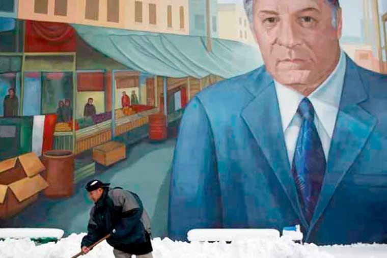 Silvaro Tlapescho shovels out a parking lot in front of the Frank Rizzo mural in the Italian Market after a snow storm hit the region in January 2011. ( David Maialetti / Staff Photographer )