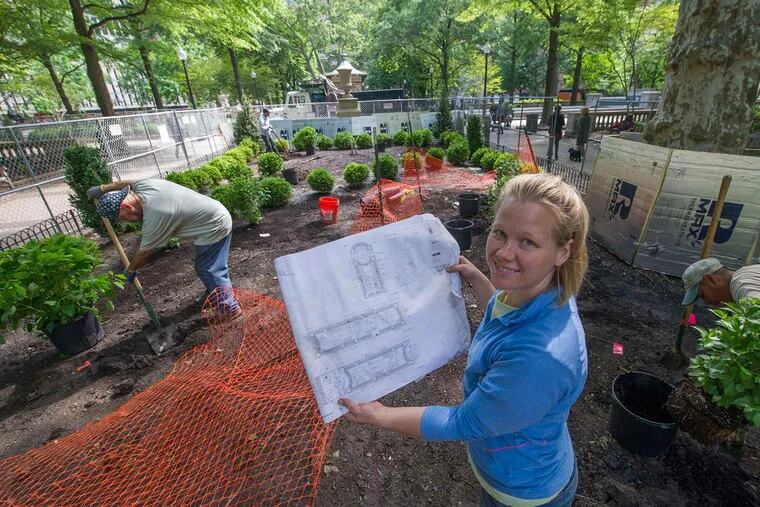 Liz Haegele, owner of Fine Garden Creations, holds up blueprints of the renovation plans for the Goat Garden in Rittenhouse Square. She contacted growers across the East Coast before finding a boxwood source outside Chicago.