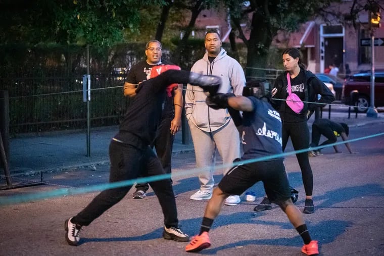 Philadelphia Police Captain Nashid Akil, center, and Officer George Gee, left, coaching in the Guns Down Gloves Up boxing program in October 2022.