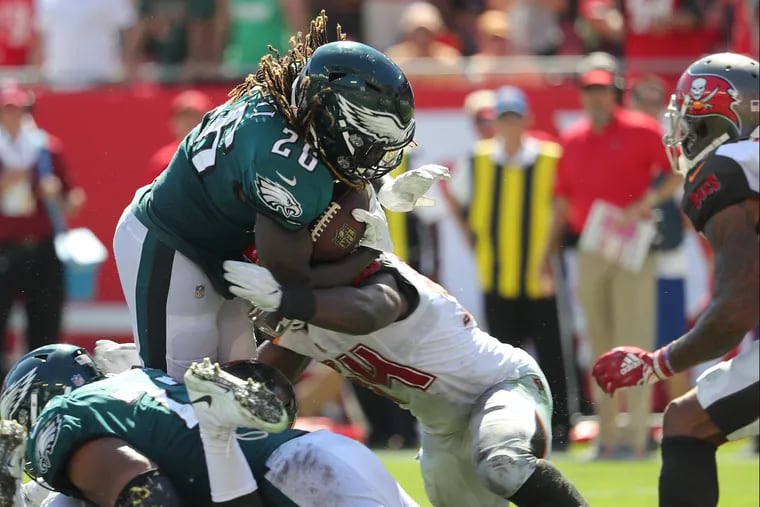 Eagles' Jay Ajayi is stopped by the Buccaneers' Lavonte David, right, on a 4th quarter run. Philadelphia Eagles lose 27-21 to the Tampa Bay Buccaneers in Tampa, Fl on September 16, 2018. DAVID MAIALETTI / Staff Photographer