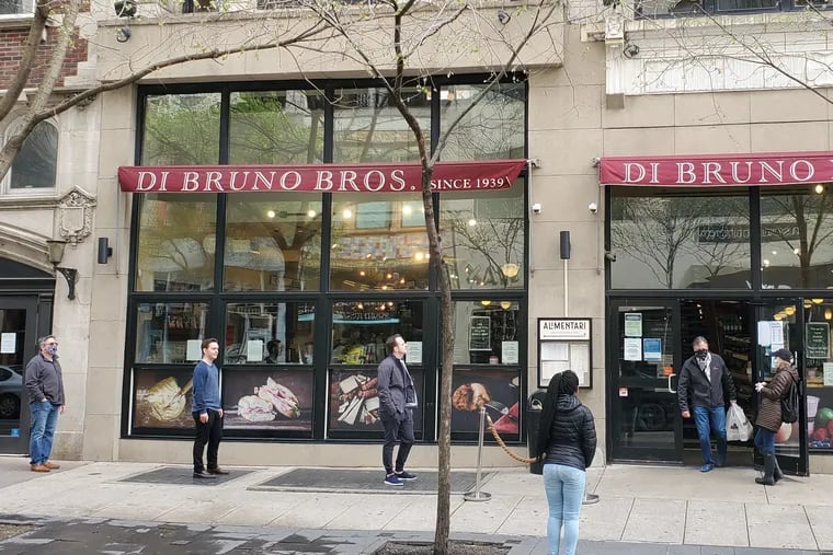 Customers follow social distancing rules outside Di Bruno Bros. market at 1730 Chestnut St. in Center City.