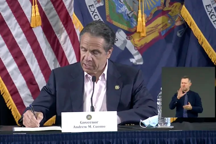 Then-Gov. Cuomo signed a bill giving death benefits to the families of certain government workers who were killed by coronavirus, Saturday, May 30, 2020 in New York. (Office of Governor Andrew M. Cuomo via AP)