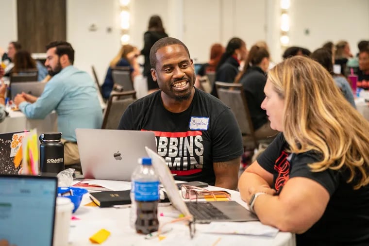 Brandon Bigelow, Dobbins climate manager, left, and Meredith Cole, 9th grade school counselor, right, at the 9th Grade Success Network Summer Summit, at the Courtyard by Marriott Philadelphia City Avenue, Wednesday, August 16, 2023.