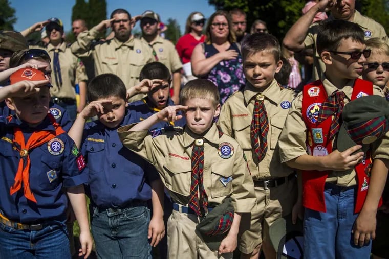 Eli Whalen, 10, purses his lip as he salutes the lives of fallen soldiers.