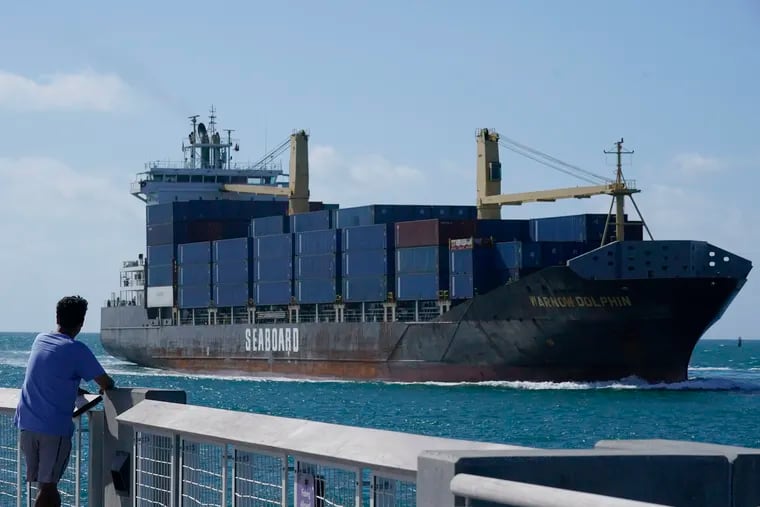 A man watches as a container ship passes by.  Small businesses can participate in the global marketplace.  And experts stand ready to teach their owners how.