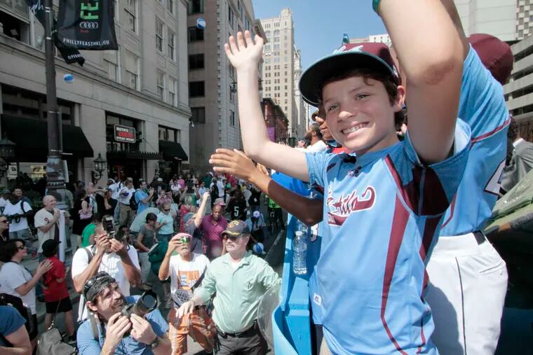 Taney Dragons' Eli Simon waves to the crowd. The Dragons captured the city's heart during the Little League World Series.