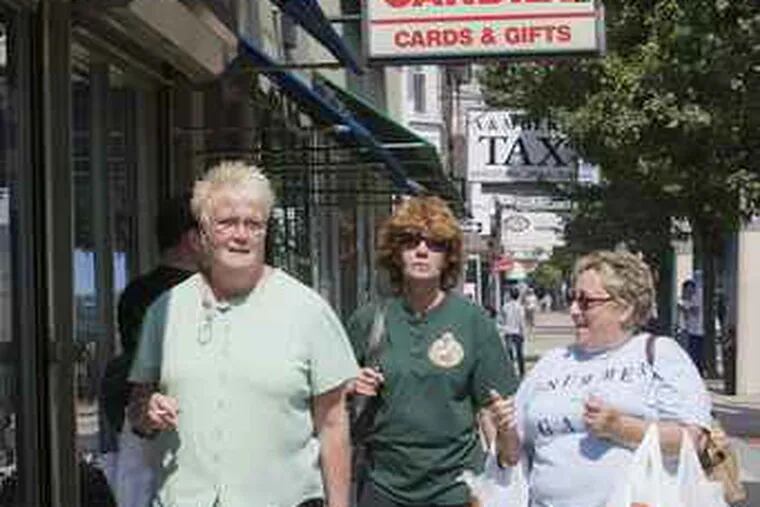 Angie O'Mara, left, Rosanne Alessio, back center, and Kit McGarry, right, use their lunchbreak to do some shopping on Frankford Ave. in Mayfair, in Philadelphia, August 13, 2008. Jessica Griffin / Philadelphia Daily News