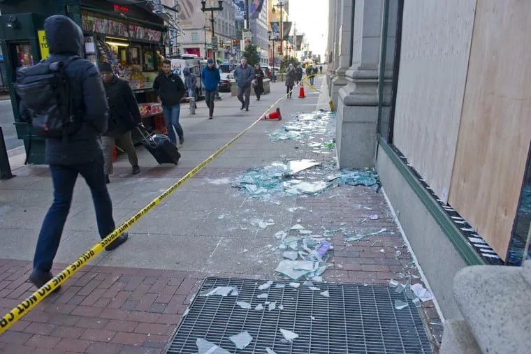 Broken glass from the busted windows of Macy's near City Hall lies on the sidewalk Monday morning after last night's Eagles revelry in Center City.