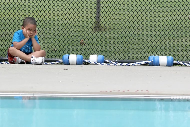 In this 2011 photo, Mekhi Harris sits impatiently by the Mander Recreation Center pool Wednesday as he waits for Philadelphia's 70 public pools to open for the summer.
