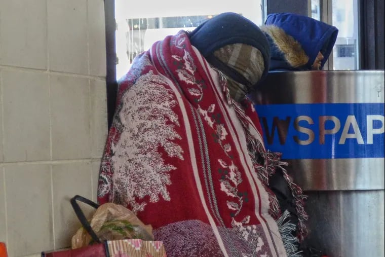 An unidentified homeless woman, left, shields from the cold inside a terminal of the Walter Rand Transportation Center in Camden, N.J. Tuesday, January 2, 2018.