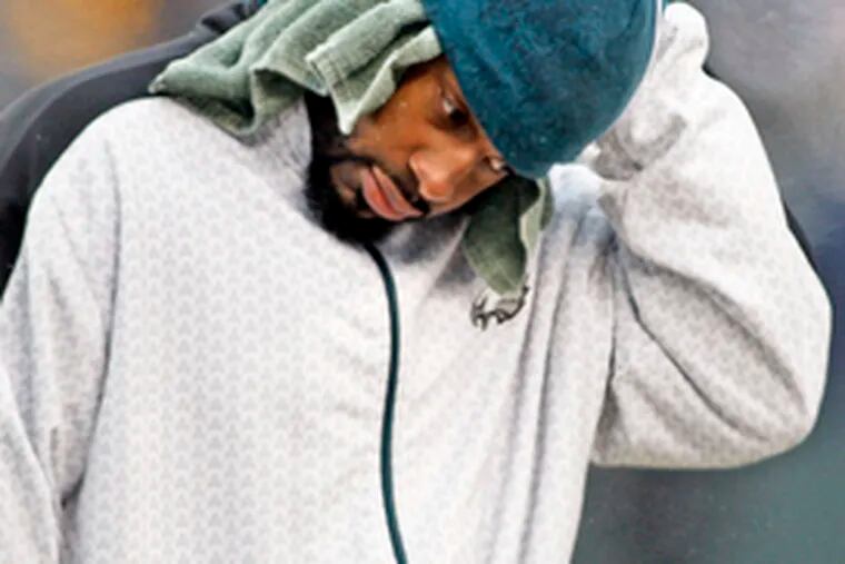 Injured Eagles quarterback Donovan McNabb wears towel under his cap to keep dry in the rain.
