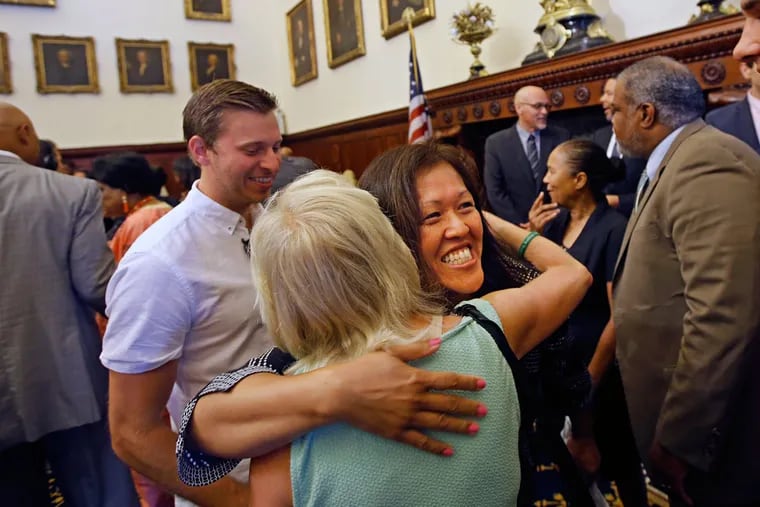 Kimlime Chek-Taylor (center), principal of South Philadelphia High School, gets a big hug from a supporter after it was announced that the school was one of nine named Community Schools.