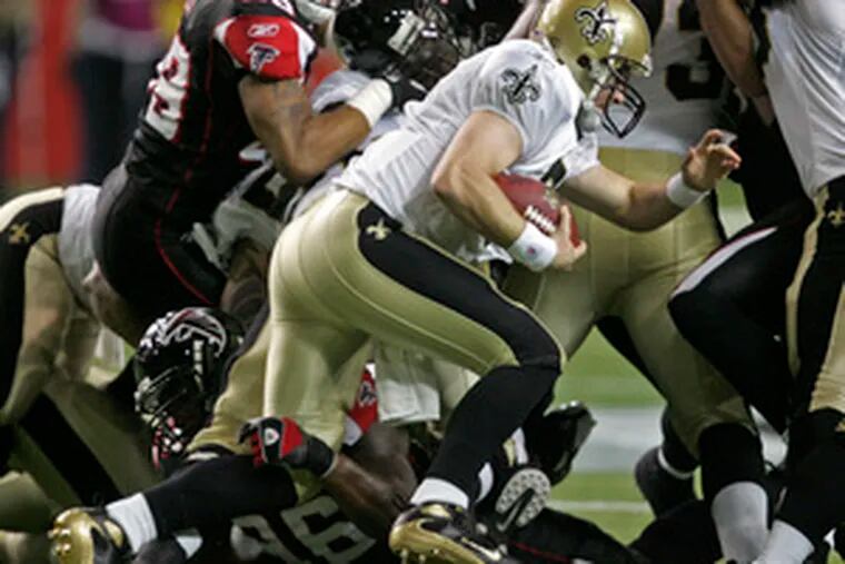 New Orleans quarterback Drew Brees is stopped for no gain as Montavious Stanley (bottom) of the Falcons gets hold of his leg. Last night&#0039;s game ended too late for this edition.