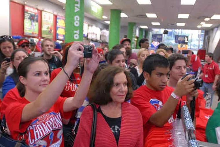 Phillies fans crowd into the Modell's on Chestnut Street in Center City, some trying to get a picture of pitcher Cliff Lee.