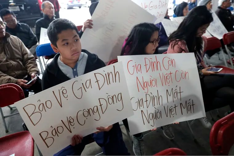 Bill Nguyen, 12, and Jade Nguyen, 9, hold signs at a rally protesting President Donald Trump's deportation policy to deport Vietnamese refugees, at the Mary Queen of Vietnam Church in New Orleans, Thursday, Dec. 20, 2018. (AP Photo/Gerald Herbert)