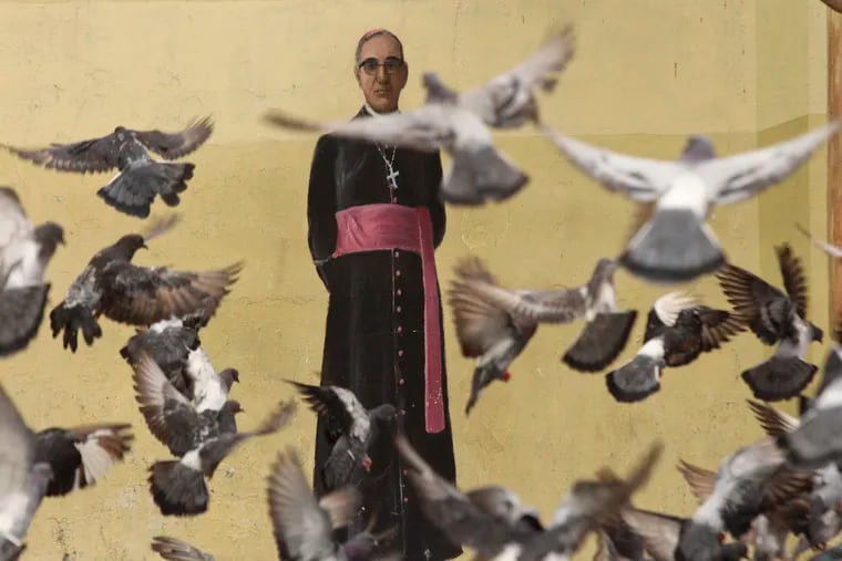 Pigeons fly in front of a mural depicting Archbishop Oscar Arnulfo Romero, on a wall of the Metropolitan Cathedral in San Salvador, El Salvador. Romero will be canonized in Rome by Pope Francis on Sunday. Romero was assassinated in 1980 while celebrating Mass by a gunman hired by right-wing death squads. (AP Photo/Salvador Melendez)