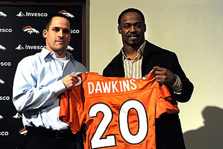 Brian Dawkins, talks with the media while holding up his new Broncos jersey. (AP Photo/Reza A.Marvashti)