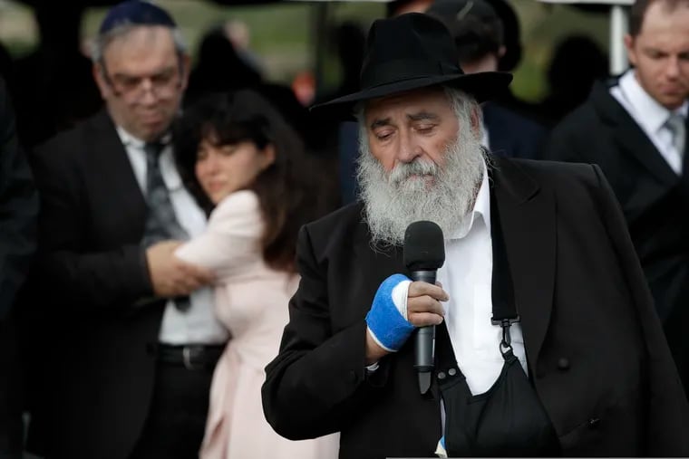 Rabbi Yisroel Goldstein speaks during funeral services for shooting victim Lori Kaye as Kaye's daughter Hannah, second from left, holds onto her father, Howard, Monday, April 29, 2019, in San Diego. Lori Kaye was killed when a man opened fire two days earlier inside a synagogue near San Diego, as worshippers celebrated the last day of a major Jewish holiday.