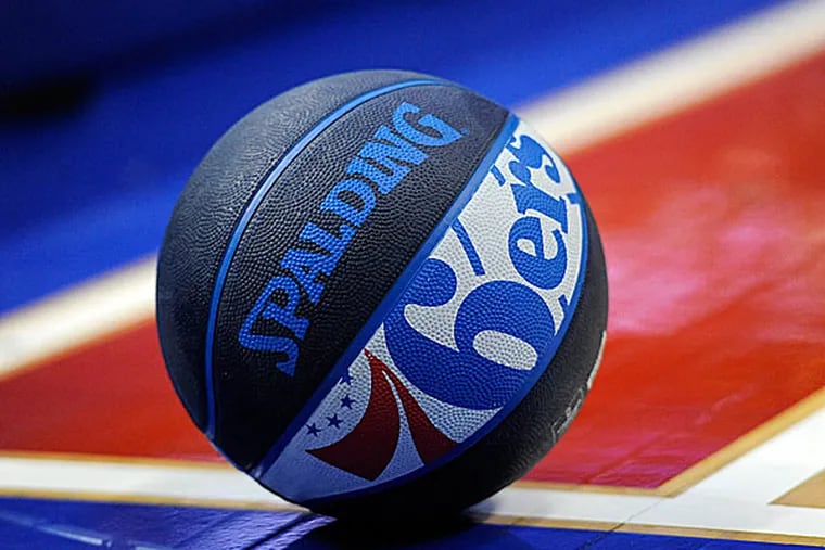 A basketball with the 76ers logo rests on the court at the Wells Fargo Center. (Michael Perez/AP)