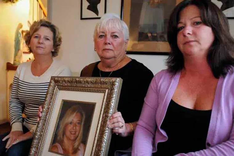 Eileen DiFrancesco, mother of Leslie Delzingaro, hold a portrait of her with daughters Laura Davis (left) and Lisa Naughton beside her.  November 22, 2013 ( RON TARVER / Staff Photographer )