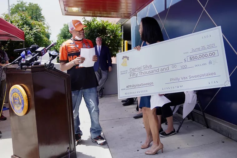 Daniel Silva (left) of Oak Lane receives a ceremonial check for $50,000 from University of Pennsylvania professor Angela Duckworth during a news conference announcing a first-round winner of the Philly Vax Sweepstakes at Maria de los Santos Health Center in North Philadelphia on June 25, 2021. The giveaways were intended to boost city vaccination rates, but Penn researchers concluded the incentive program wasn't effective.