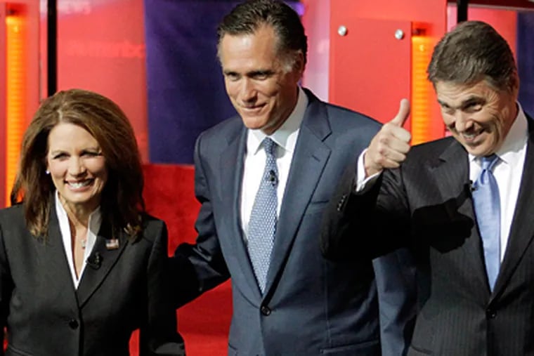Candidates Michele Bachmann, Mitt Romney (center), and Rick Perry take the stage before the start of the GOP presidential debate at the Reagan library in Simi Valley, Calif. (Jae C. Hong / Associated Press)