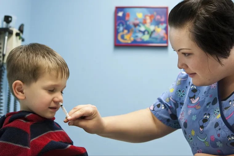 Three-year-old Clayton Mathiason, of Omaha, Neb., receives a flu vaccine via nasal spray from nurse Amanda Stern at Physician's Clinic in Omaha, Neb., Oct. 6, 2009.