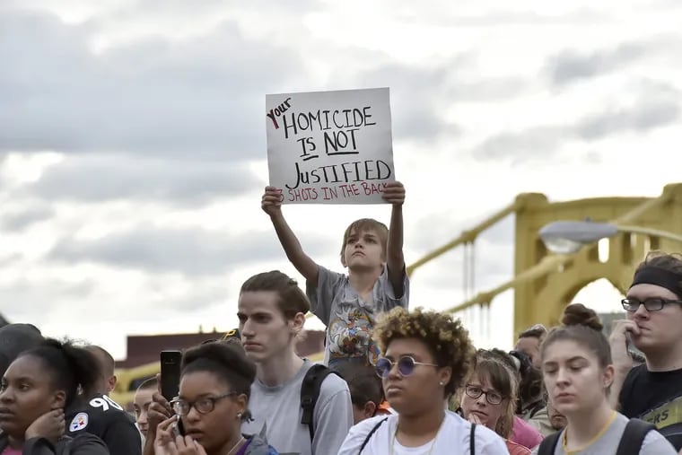 Demitry Hood, 9, of Robinson holds a sign just across the 9th street bridge during a protest of the shooting death of Antwon Rose Thursday, June 21, 2018.