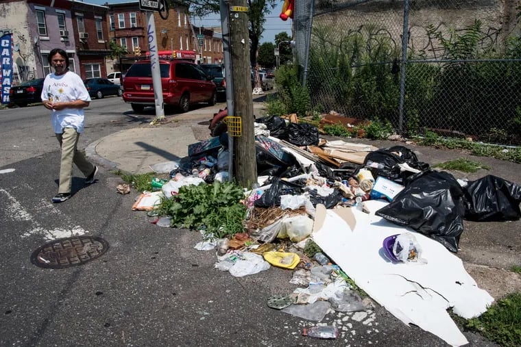 A man crosses Tusculum and Front Streets in the city's Fairhill section. Candidates for City Council and Mayor need to offer plans to combat the deep poverty in neighborhoods like Fairhill, say the co-executive directors of Resolve Philadelphia.
