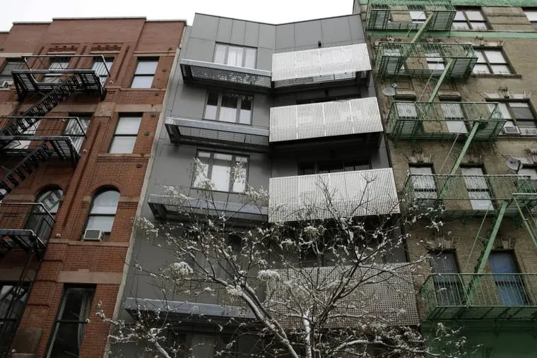 A new building sits between two older style buildings in the East Harlem section of New York, Tuesday, Feb. 3, 2015. New York City Mayor Bill de Blasio has detailed his ambitious plans to build and preserve affordable housing throughout New York City. Programs outlined in de Blasio's State of the City speech on Tuesday also are designed to protect New Yorkers facing displacement from rising rents and harassment. (AP Photo/Seth Wenig)