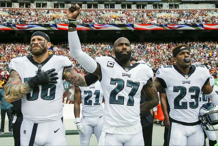 Eagles strong safety Malcolm Jenkins raises his fist with teammate defensive end Chris Long (left) and free safety Rodney McLeod during the National Anthem before the played the Washington Redskins in September.