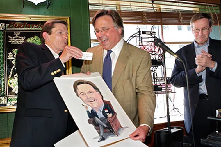 John Gilpin (left) creative director for media lab, presents Brian Tierney (middle) with Tierney's caricature and Gilpin's business card during a thank you celebration thrown by Tierney at Westy's on 15th on Thursday.