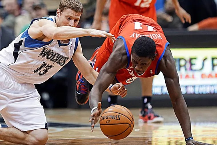 The Timberwolves' Luke Ridnour and the 76ers' Jrue Holiday scramble for the loose ball in the second half. (Jim Mone/AP)