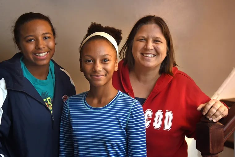 Koeberle Bull with her daughters Olivia (left), 16 and Sophia (center), 11 pose in their Lumberton home October 23, 2018. Last week Bull received a hateful racist Facebook message from a Kentucky man who threatened her children. She reported it and police tracked the man down, arrested him, and announced he had intended to shoot up a school and was armed.