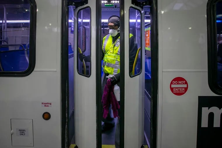 Ryan Stewart, an employee of SEPTA wipes down a bus at the Olney Transportation Center at N. Broad and Olney Ave in Philadelphia on Wednesday morning May 6, 2020. SEPTA has employees wiping down bus to control spread of Covid-19.