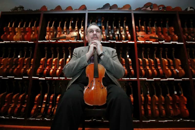 In this 2009 photo, musician David Bromberg poses with some of his 263 historic American violins in Wilmington, Del. Bromberg, known for collaborating with Bob Dylan and the Beatle’s George Harrison, was set to sell his massive collection of historic violins to the Library of Congress, but the deal has fallen through. The Delaware News Journal reports that the collection will have to be broken up and sold separately after the library failed to find a donor.