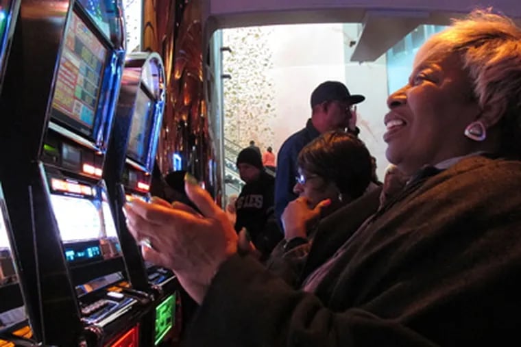 Lorraine Capers, of Brooklyn, N.Y., claps after winning seven free spins on a slot machine at the new $2.4 billion Revel casino resort moments after it opened in Atlantic City, N.J., on Monday, April 2, 2012. (AP Photo/Wayne Parry)