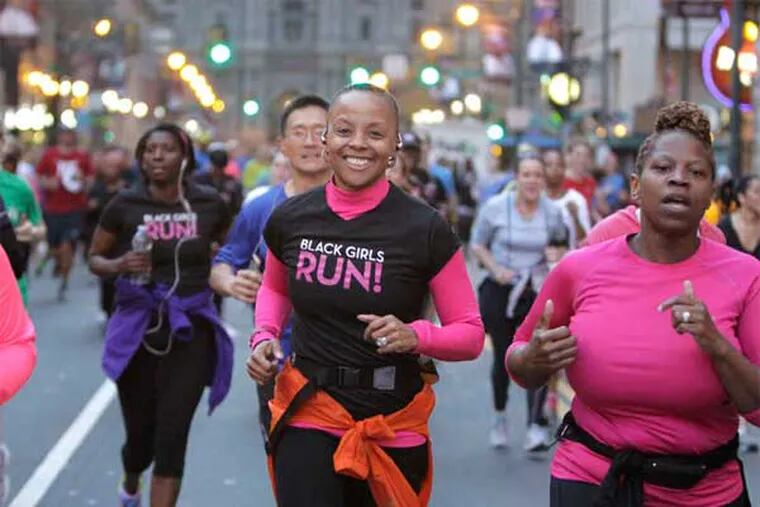 Beverly Brown (center) smiles as she runs with the group &quot;Black Girls Run&quot; down Market Street from City Hall to Independence Mall in a show of support for Boston following Monday's bombing at the renowned marathon. (Elizabeth Robertson / Associated Press)