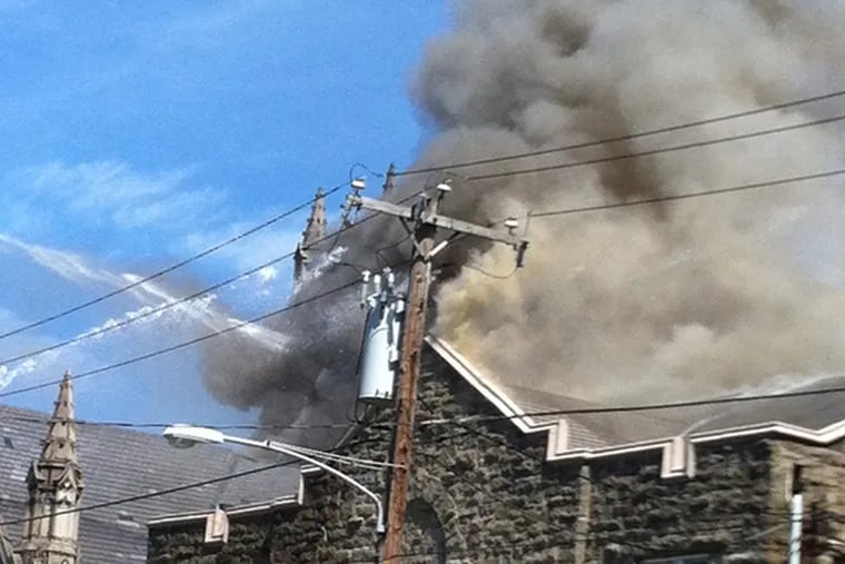A four-alarm fire in Philadelphia's East Oak Lane is said to be a building used as a church. Firefighters are on the scene at 6629 North 12th St. (Jessica Parks / Inquirer staff)